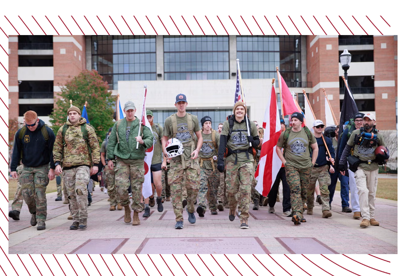 Students dressed in camouflage march together in front of Bryant-Denny Stadium